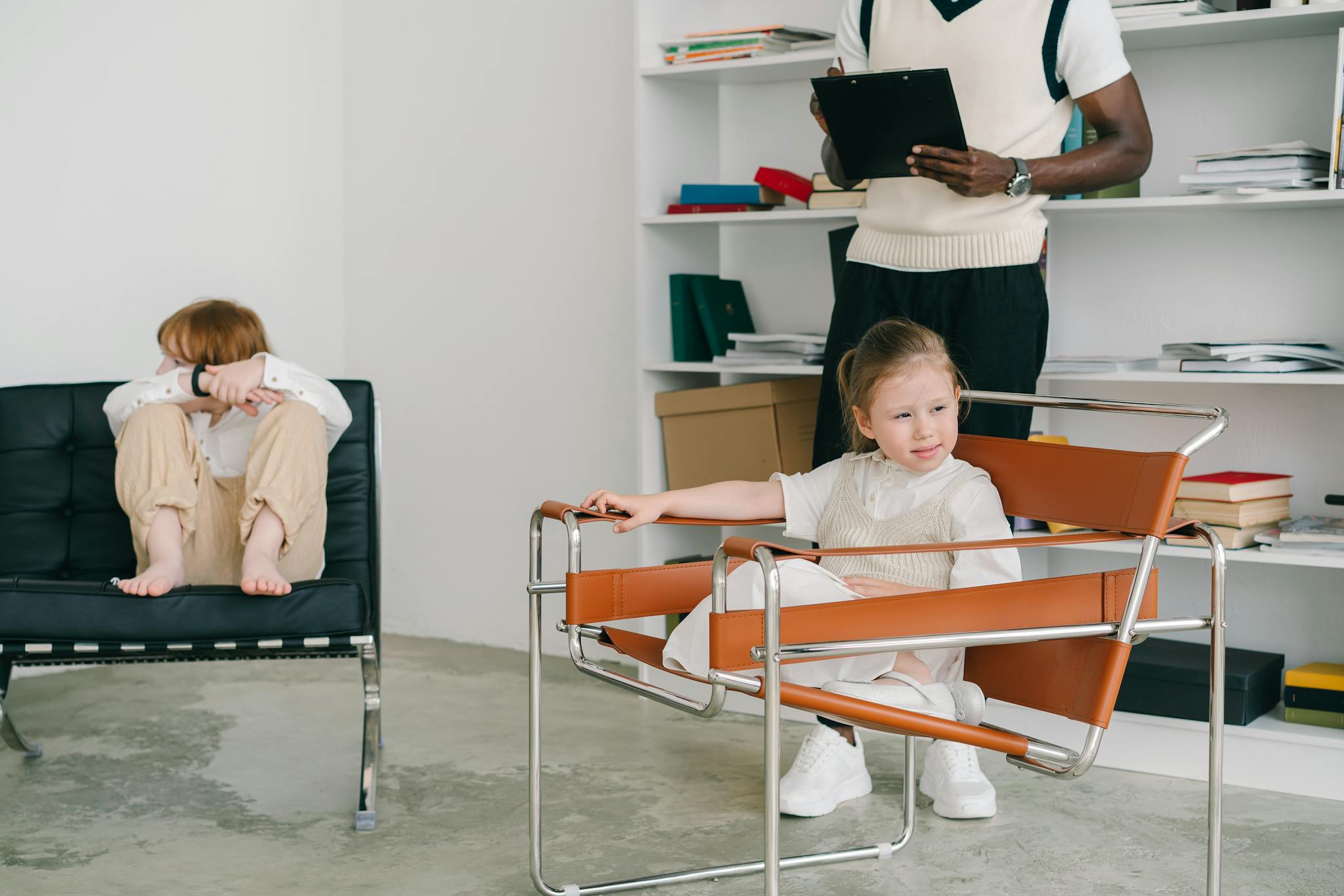 Children engage in a therapy session while the therapist observes with a clipboard.