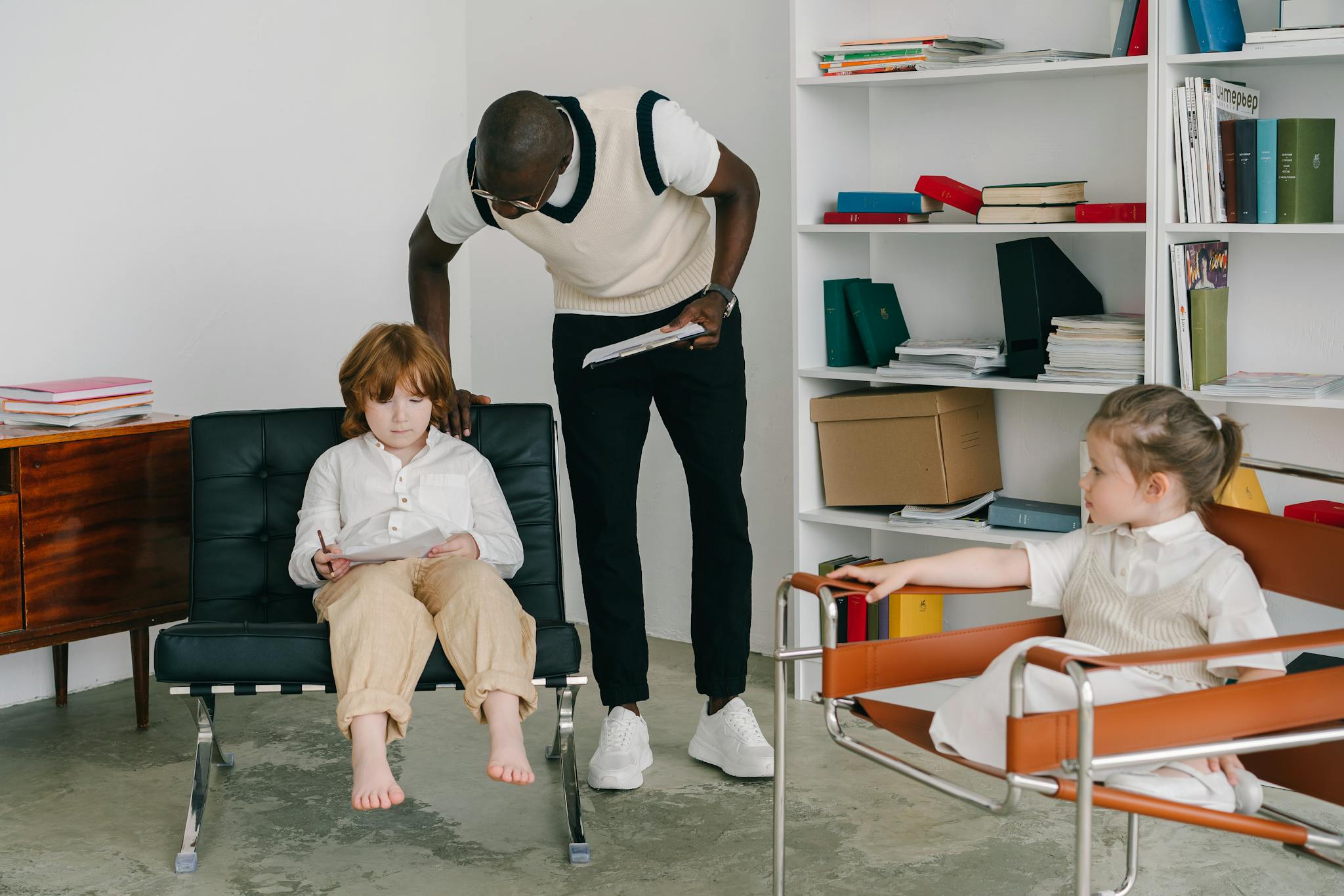 Therapist engaging with children in a modern office environment, focusing on child development.